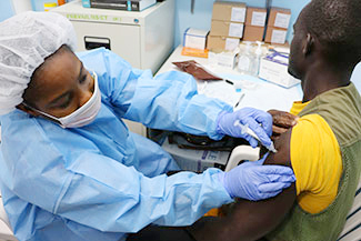 Male patient receiving vaccine from medical worker.