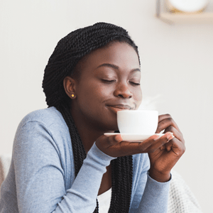 woman smelling a cup of coffee
