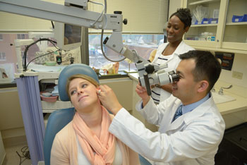 NIDCD neuro-otologist Wade Chien, M.D., assisted by Angeline Thompson, R.N., perform otomicroscopy on a research volunteer in the NIDCD clinic.