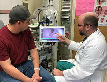 Dr. Allen points to a screen image as he discusses papillomatosis with a patient.
