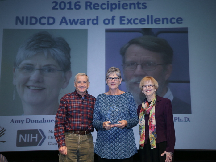 Amy Donahue, Ph.D. (center), with NIDCD Director James F. Battey, Jr., M.D., Ph.D. (left), and NIDCD Deputy Director Judith Cooper, Ph.D. (right).