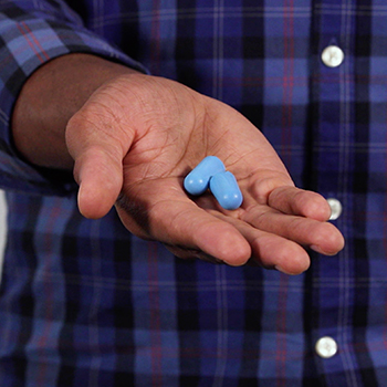 A man demonstrating the correct way to use formable earplugs to help prevent noise-induced hearing loss.