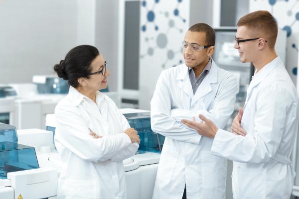 A group of scientists conversing in a lab. 
