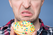A man makes a scorned face at a sugary donut.