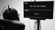 A man looks at a screen where his words appear while wearing a device on his head.