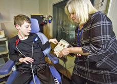 Dr. Brewer, right, conducts a word recognition test on a clinical trial participant in the audiology clinic.