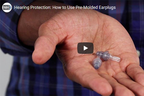 A man demonstrating the correct way to use pre-molded earplugs to help prevent noise-induced hearing loss.