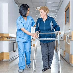 healthcare working steadying a woman using a walker