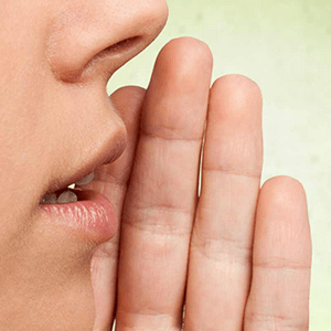 woman putting hand to mouth to speak